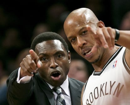 Avery Johnson, entrenador de los Nets, da instrucciones a su base, Keith Bogans.