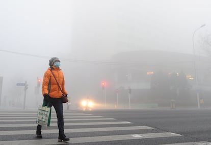 El Centro Nacional Meteorológico ha advertido de que se prevé que el alto nivel de polución afecte a unas diez provincias del país y que se extienda hacia el sur. En la imagen, una persona cruza por un paso de peatones en Dalian (China).