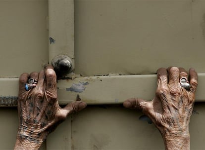 Una manos delgadas de mujer se agarran a un camión del ejército iraquí, poco antes de que se inicia el reparto de alimentos en Ciudad Sadr, en Bagdad.