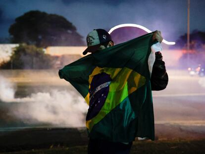 Un hombre se cubre con una bandera durante una protesta por la derrota de Bolsonaro en Barueri (Brasil).