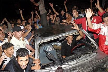 Una multitud de palestinos clama venganza desde el coche calcinado por disparos israelíes en el campo de Nuseirat.