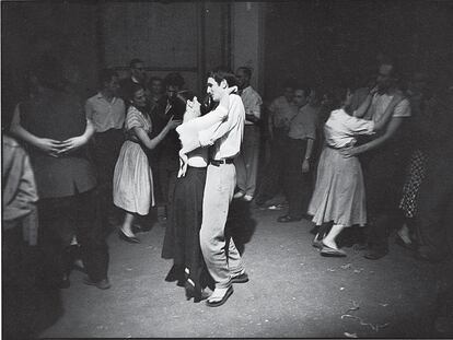 Fotografía de Willy Ronis del libro 'Aquel día' titulada 'Rue des Canettes', tomada el 14 de julio de 1955. El fotógrafo, influido por Rembrandt, tenía especial afición por los claroscuros, como sucede en este baile.