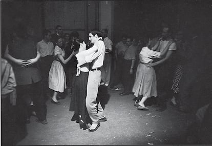 Fotografía de Willy Ronis del libro 'Aquel día' titulada 'Rue des Canettes', tomada el 14 de julio de 1955. El fotógrafo, influido por Rembrandt, tenía especial afición por los claroscuros, como sucede en este baile.