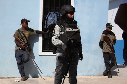 Un integrante de la Guardia Nacional y dos jóvenes autodefensas resguardan Ayahualtempa (Estado de Guerrero), el 31 de enero.