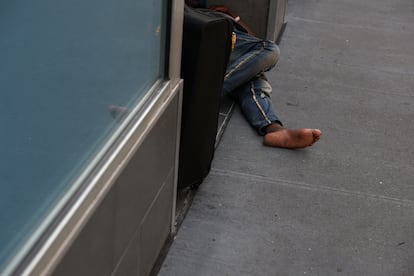 Un hombre duerme a la entrada de un comercio cerrado en Midtown, en junio.