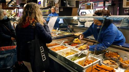 Una mujer compra en un establecimiento de comida preparada, en marzo pasado.