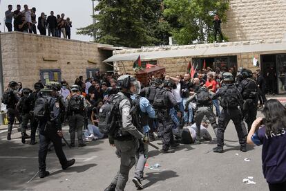 El féretro de la periodista, que iba cubierto por la bandera palestina, ha estado a punto de caer al suelo cuando los agentes han tratado de disolver a los congregados a la salida del hospital