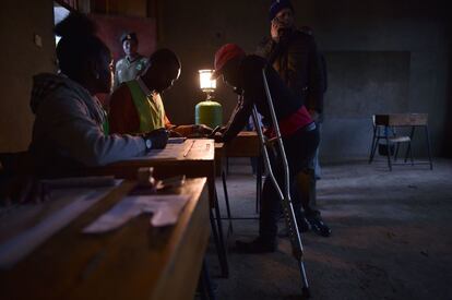 Un funcionario independiente de la Comisión Electoral y de Límites (IEBC) revisa la documentación de un votante en la escuela primaria de Moi, en Nairobi, este jueves, 26 de octubre de 2017.