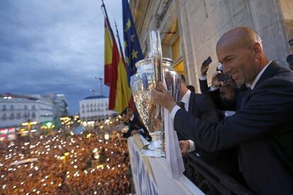 El entrenador del Real Madrid Zinedine Zidane, con el trofeo de la Liga de Campeones, durante la celebración del título en el balcón de la sede de la Comunidad de Madrid en la Puerta del Sol.