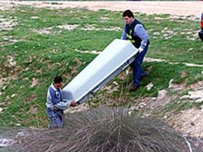 Agentes de la policía judicial de la Guardia Civil, ayer, retiran el cadáver del niño caído al pozo.