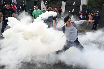 Cerca de la sede del Congreso en Lima, un manifestante lanza una granada de gas lacrimógeno a la policía, este lunes. Dos manifestantes murieron durante esta jornada de protestas contra el arresto de Pedro Castillo, según fuentes oficiales.