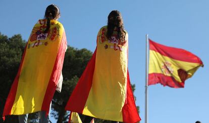 Dos jóvenes con banderas de Espana asisten a la manifestación.