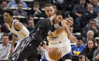 Ricky Rubio trata de superar a Curry.