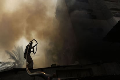 Un hombre apaga las llamas de un incendio tras un fuerte bombardeo en Gaza, el 30 de julio de 2014.