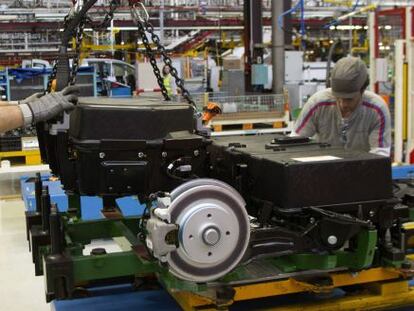 Dos operarios colocan las bater&iacute;as de la furgoneta el&eacute;ctrica Citro&euml;n Berlingo en la cadena de montaje de la planta de PSA. 