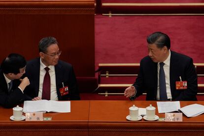 Chinese President Xi Jinping, right, speaks to Politburo Standing Committee members Wang Huning, left, and Li Qiang during a session of China's National People's Congress (NPC) at the Great Hall of the People in Beijing, Tuesday, March 7, 2023.