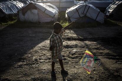 Un niño juega con una cometa mientras atardece en el campamento de refugiados.