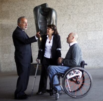 CON LAS VÍCTIMAS. Pere Navarro ha trabajado con intensidad con las asociaciones de víctimas de accidentes de tráfico. En esta imagen, posa con dos personas afectadas por sendos siniestros, a las puertas de la sede central de la DGT en Madrid, donde mandó colocar una escultura en recuerdo de los fallecidos (al fondo).