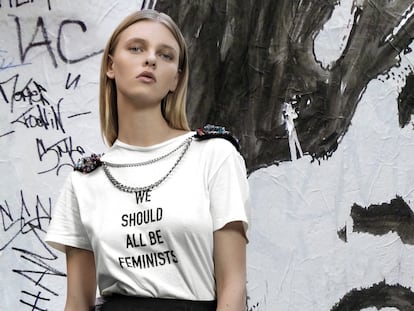 Camiseta blanca con mensaje “We Should All Be Feminists” (todos deberíamos ser feministas) de Dior. 
Su directora creativa, Maria Grazia Chiuri, se inspiró en el título de un ensayo de la escritora Chimamanda Ngozi Adichie. Falda de volantes en tul negro de Dior, cadena con hombreras de Mibuh, y pulsera y anillo de Luxenter. 