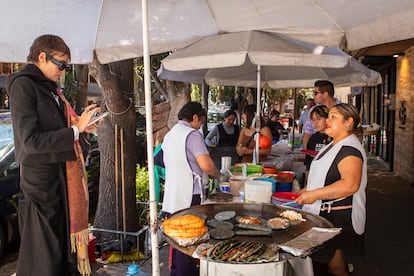 Comensales esperan y hacen fila en el puesto de quesadillas Elenita en Ciudad de México.