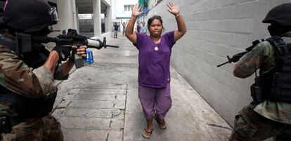 Una <i>camisa roja</i> se rinde ante dos soldados tailandeses tras la ofensiva sobre el campamento opositor en Bangkok.