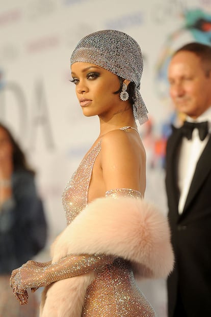 Rihanna en los Oscar de la moda, 2014. No se puede hablar del pañuelo en la cabeza como elemento de moda sin mencionar el “look” de Rihanna en la noche en la que fue coronada oficialmente como icono de moda, la de los premios CFDA en el año 2014. La noche del 2 de junio, Rihanna brilló de manera casi literal con un vestido de malla completamente transparente, creado por Adam Shelman bajo petición expresa de la artista, con un pañuelo estilo “durag” a juego, decorados con más de 200.000 cristales de Swarovski. Anna Wintour presentó su galardón y reconoció que Rihanna no seguía la moda, si no que la creaba.  (Jamie McCarthy/WireImage)