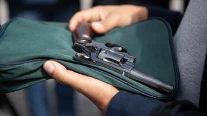 Un hombre muestra un arma de fuego al acudir a un programa de desarme en Ciudad de México, en enero de 2025.