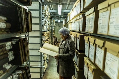 Ruth Borja, la directora del Archivo General de la Nación, observa un documento entre los pasillos del archivo. 