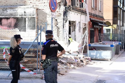 La policía vigila el edificio acordonado y apuntalado en Vallecas tras una explosión de gas, en la calle Manuel Maroto.