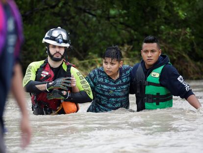 Civil protection workers rescue a youth in the aftermath of Storm Hanna in El Carmen, on the outskirts of Monterrey, Mexico July 27, 2020. REUTERS/Daniel Becerril