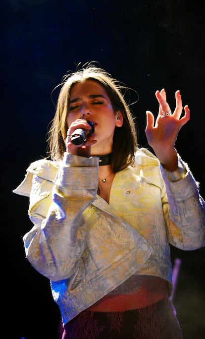 Cuando la cantante albanesa Dua Lipa lanzó su primer disco, en 2016, titulado con su propio nombre, ella era una de tantas jóvenes que intentaba abrirse paso en la escena musical británica, en aquel momento dominada por los sonidos urbanos, que a su vez estaban claramente definidos por la estética deportiva y lo que ahora pomposamente se llama 'athleisure'. Dua Lipa consiguió su primer gran éxito en las listas con el quinto sencillo de este primer trabajo y fue gracias a que la compañía cosmética Revlon lo escogió para una campaña publicitaria en la que pretendía representar la falta de prejuicios raciales, la diversidad étnica y la frescura de la juventud británica. En aquella campaña, como en la mayoría de las apariciones y actuaciones de aquella época, su estilo estuvo profundamente marcado por prendas deportivas, muy cómoda, pero al mismo tiempo con un claro twist fashionista. Esta imagen pertenece a una actuación en Orlando, Florida, en 2017.