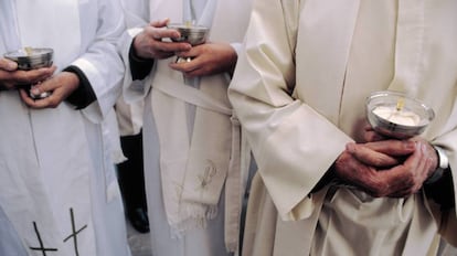 Sacerdotes con cálices durante una misa.