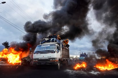 Un grupo de manifestantes indígenas pasa junto a bloqueos de carreteras en llamas mientras se dirigen hacia Quito, después de una semana de protestas contra las políticas económicas y sociales del presidente Guillermo Lasso, en Machachi, el 20 de junio de 2022. 