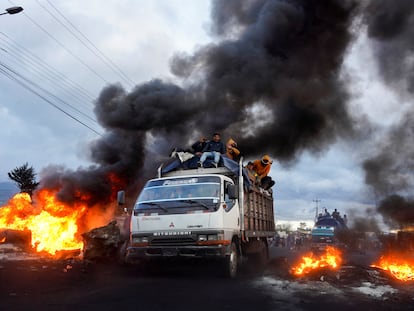 Un grupo de manifestantes indígenas ecuatorianos pasa junto a bloqueos de carreteras en llamas mientras se dirigen hacia Quito, después de una semana de protestas contra las políticas económicas y sociales del presidente Guillermo Lasso, en Machachi, el 20 de junio de 2022.