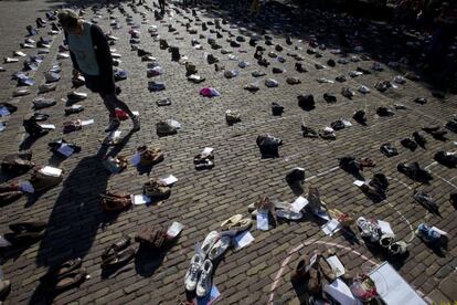 Una mujer mira a cientos de pares de zapatos que simbolizan a los que están demasiado enfermos como para unirse a la protesta durante una manifestación para llamar la atención sobre la situación de los enfermos de encefalomielitis miálgica, en La Haya (Países Bajos).