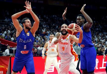 El base de España Ricky Rubio (centro) con el balón ante los jugadores de la selección italiana Danilo Gallinari (a la izquierda) y Paul Biligha.