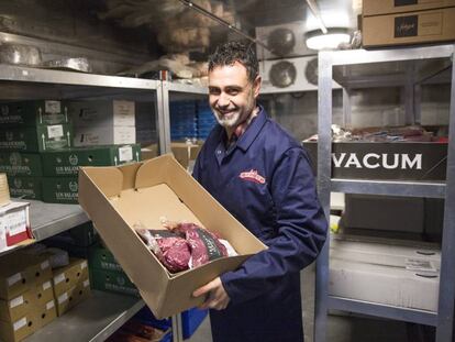 David Men&eacute;ndez, fundador de Mevalco, sostiene en sus brazos una caja con productos c&aacute;rnicos espa&ntilde;oles.