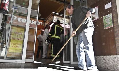 Bomberos y operarios del Mercado de Sant Martí de Barcelona trabajando en las instalaciones tras ser desalojadas por un incendio.