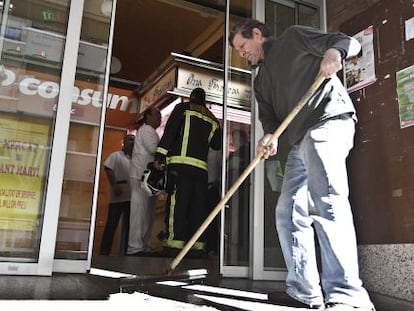Bomberos y operarios del Mercado de Sant Martí de Barcelona trabajando en las instalaciones tras ser desalojadas por un incendio.