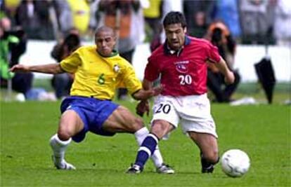 Roberto Carlos disputa el balón a Cancino en un lance del Brasil-Chile.