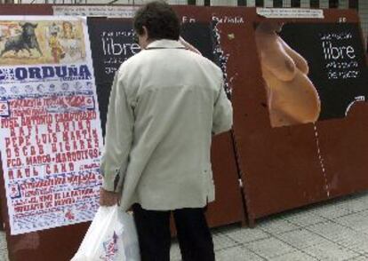 Un vecino de Vitoria contempla la cartelera taurina.