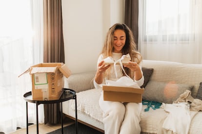 Una mujer abre unas alpargatas compradas por internet.