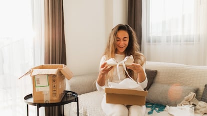 A young woman opens an online purchase. More than half of 20 to 35-year-olds currently have five items of clothing in their closet that they have never worn.