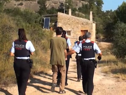 Uno de los supremacistas detenidos en la masía de La Pobla de Cérvoles (Lleida), escoltado por agentes de los Mossos d'Esquadra.