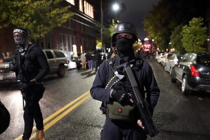 Un grupo de personas porta armas mientras marchan la noche de las elecciones, en Portland, Oregón.