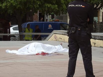 Un policía, junto al cadáver de uno de los fallecidos en Cuenca.