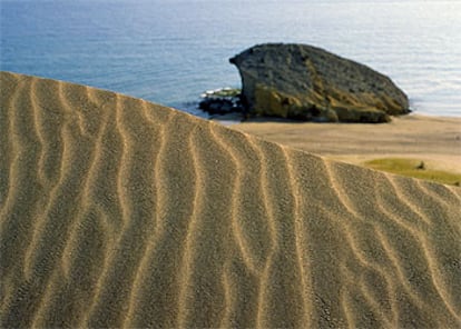 La playa de Mónsul, en el cabo de Gata (Almería), tiene una gran roca en el centro y una duna móvil.