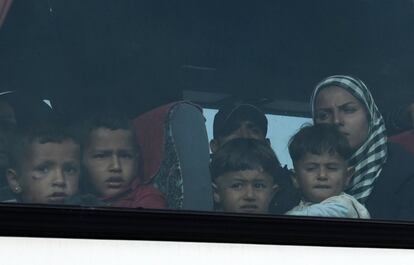 Una familia de inmigrante se traslada en autobús durante una operación para evacuar el campamento de refugiados improvisado en la frontera de Macedonia con Grecia.
