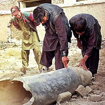 Tres jóvenes afganos observan la carcasa de una bomba norteamericana en Beni Hesar, a 8 kilómetros de Kabul.