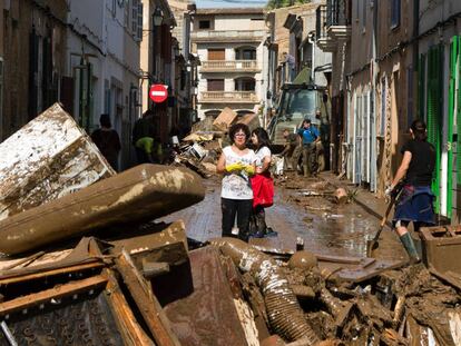 Residents remove destroyed furniture from their houses in Sant Llorenc.